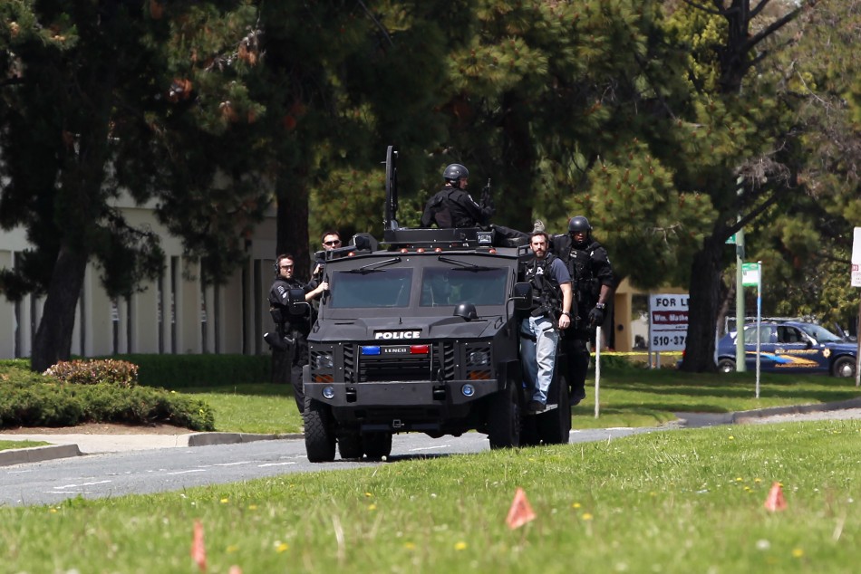 Police officers on an armored vehicle survey the scene of a shooting at Oikos University in Oakland