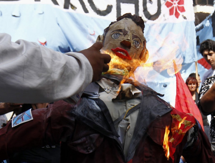 A man sets fire to an effigy depicting Prince William during a demonstration outside the British embassy in Buenos Aires (Reuters)