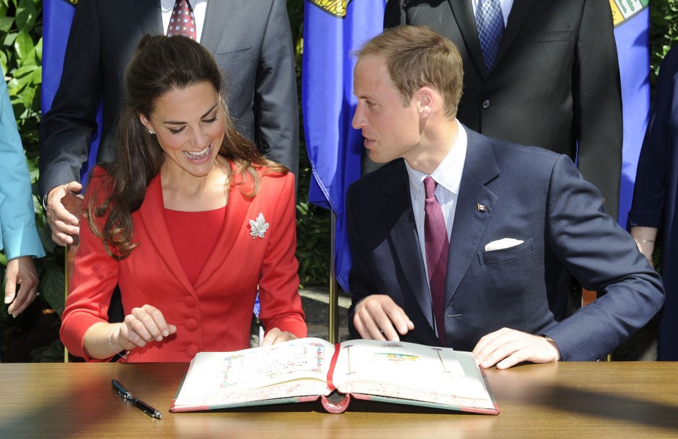 Britains Prince William and his wife Catherine, Duchess of Cambridge, react during a signing ceremony at the Calgary Zoo