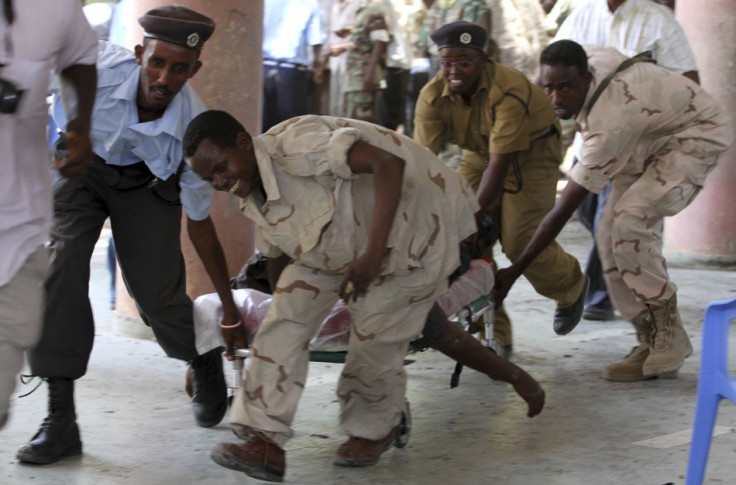 Soldiers carry the body of the chairman of Somali football federation after an explosion at the national theatre in Mogadishu