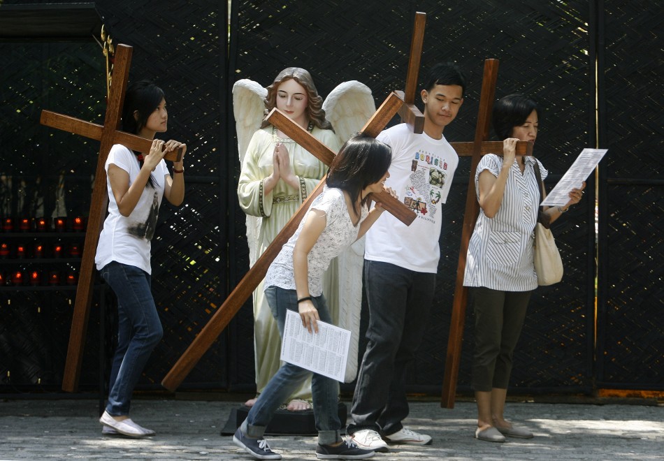 Catholic faithful carry crosses as they pray at the Stations of the Cross while doing Visita Iglesia on Maundy Thursday at a Church in Quezon City