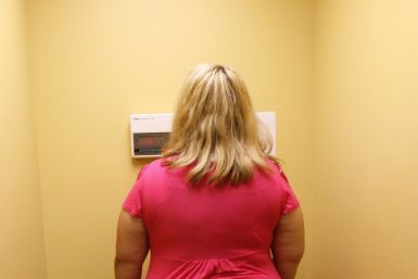 An obese woman looks at her weight - Reuters