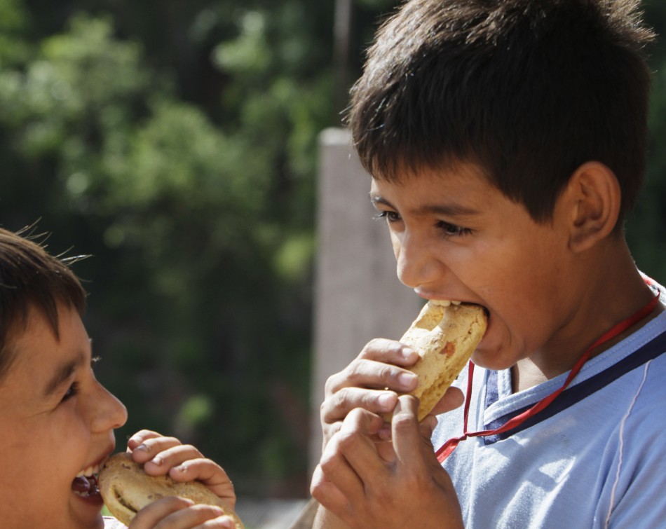 Paraguayan boys eat chipas during Easter Week celebrations in Asuncion