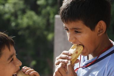 Paraguayan boys eat chipas during Easter Week celebrations in Asuncion