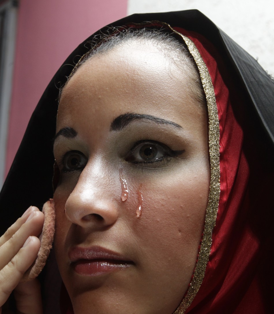 An actor applies make-up before taking part in a re-enactment of the Via Crucis in a procession during Good Friday celebrations in Luque