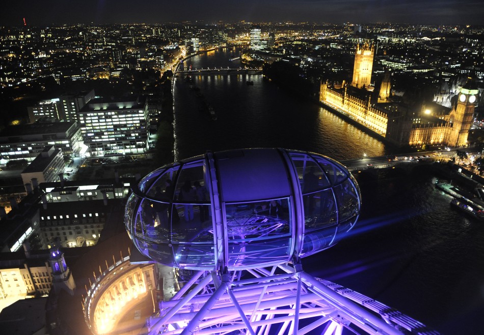 Passengers in a pod of the London Eye wheel view The Houses of Parliament and the centre of London at dusk