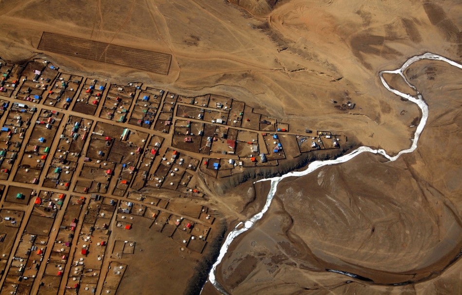 A frozen river is seen next to a group of houses located on the outskirts of the Mongolian capital city of Ulan Bator