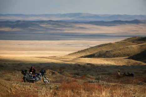 A small-scale miner takes a break from digging on hills surrounding grasslands located around 200km (62 miles) south-west of the Mongolian capital city Ulan Bator