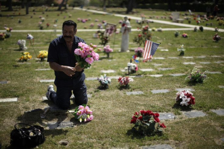 Man puts flowers on grave at pet cemetery in Huntington Beach