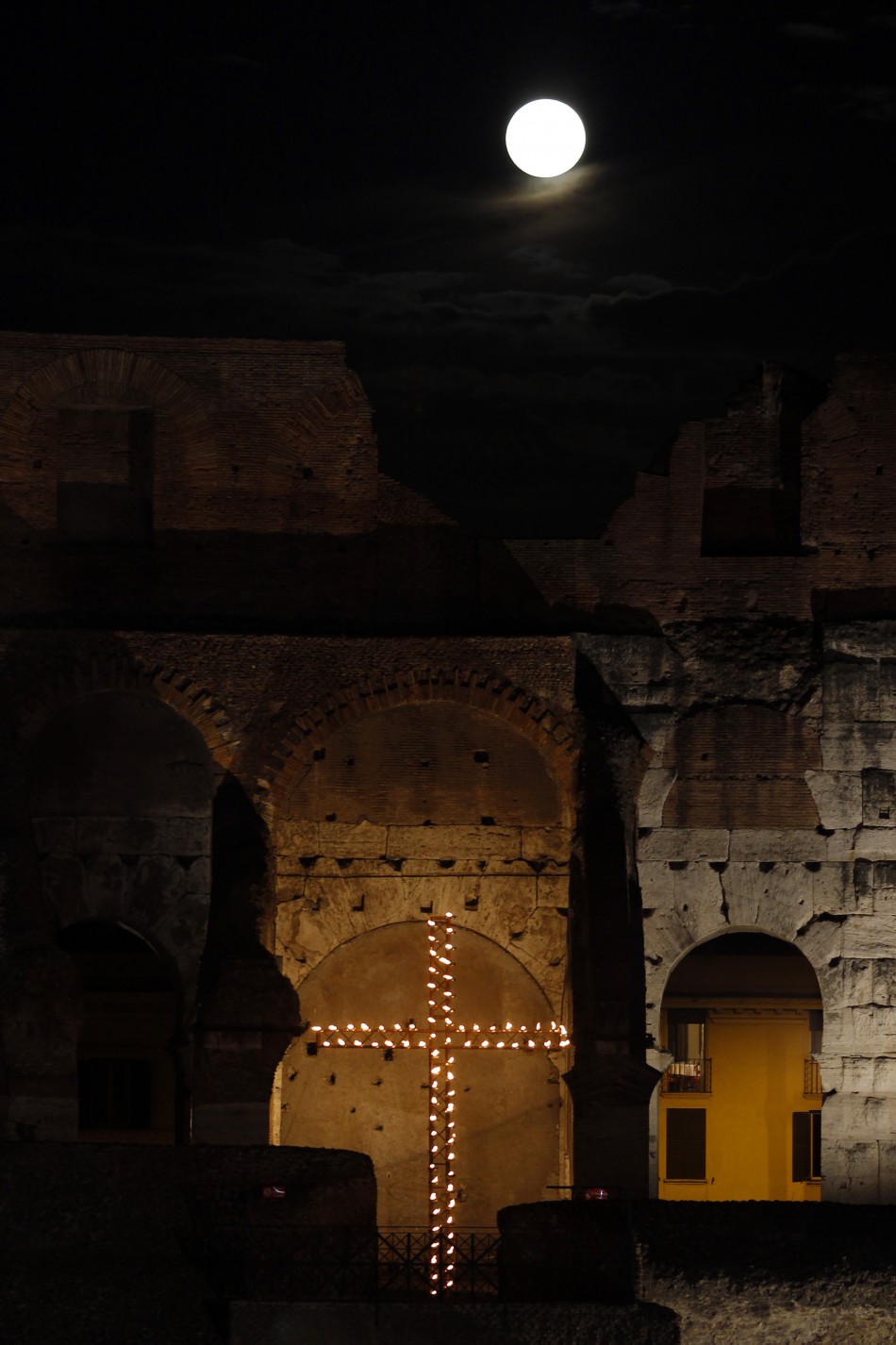 The full moon raises over the Colosseum before the Via Crucis Way of the Cross procession in downtown Rome