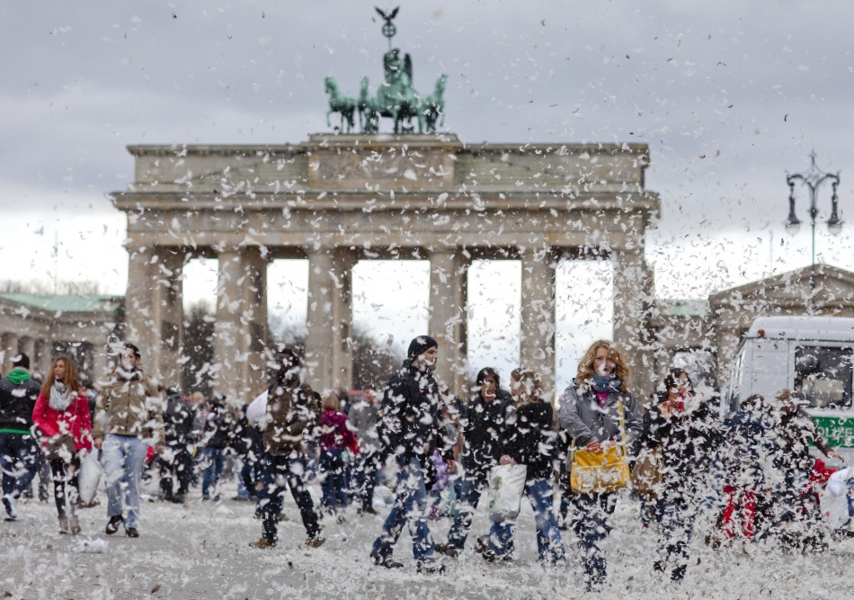 People walk near Brandenburg Gate as feathers fill air after pillow fight flashmob in Berlin