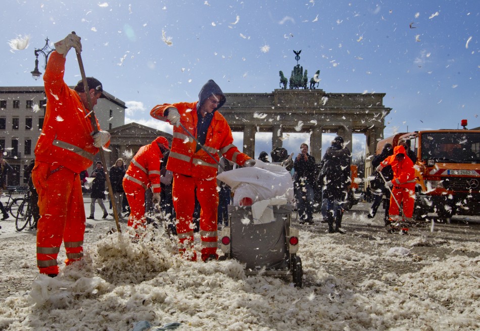 Municipal workers clean up feathers after pillow fight flashmob at Brandenburg Gate that in Berlin