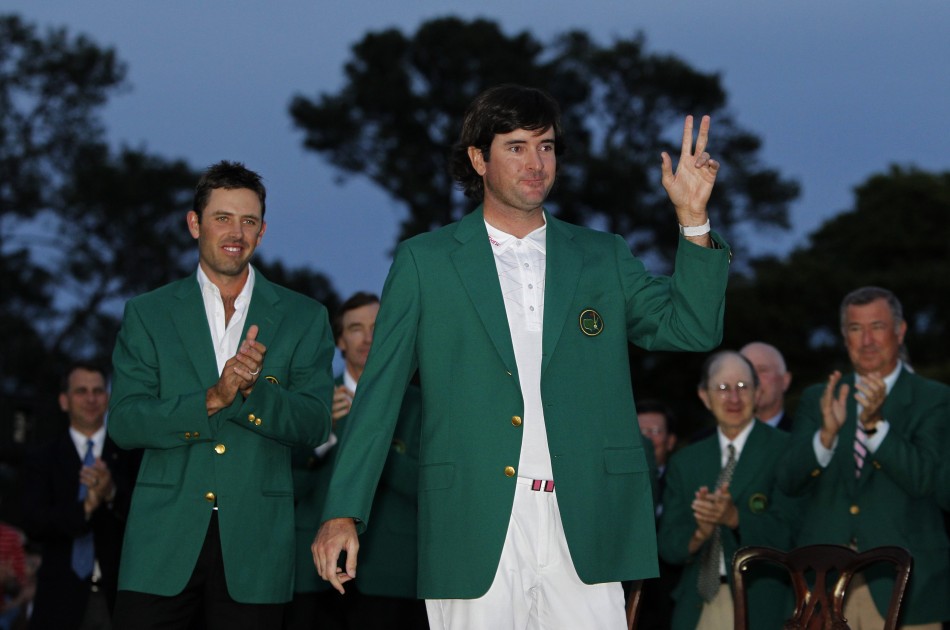Bubba Watson of the U.S. receives his green jacket from 2011 champion Charl Schwartzel of South Africa after winning a playoff to become champion of the 2012 Masters Golf Tournament in Augusta