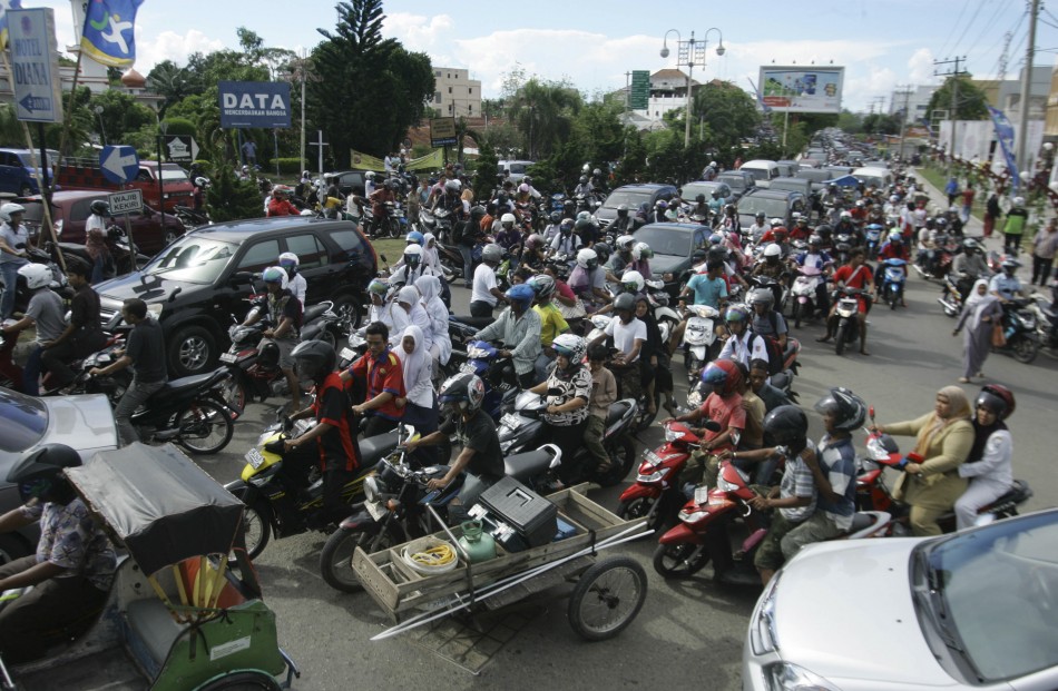 People riding motorbikes and cars packed the street in Banda Aceh after a strong earthquake struck Indonesia province