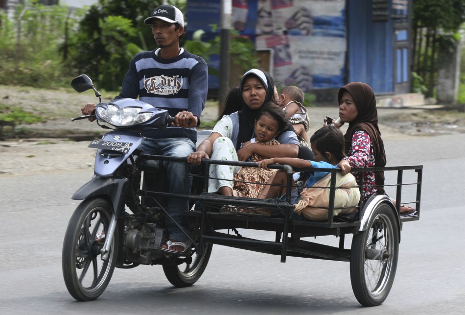 A man evacuates his family in a motorcycle in Banda Aceh after a strong earthquake struck Indonesia province