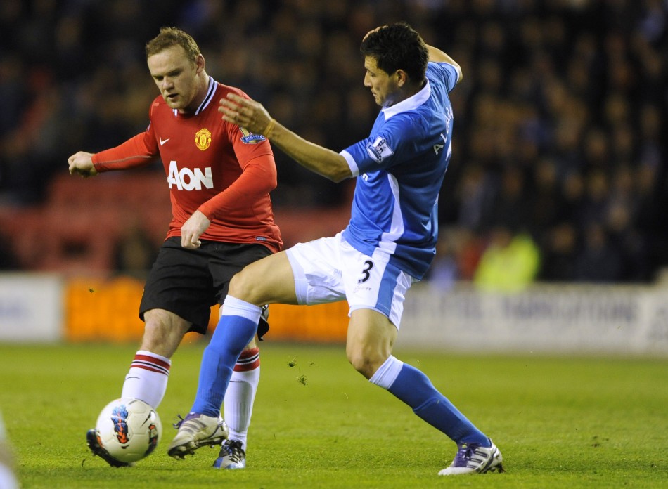 Wigan Athletic039s Alcaraz challenges Manchester United039s Rooney during their English Premier League soccer match at the DW Stadium Wigan