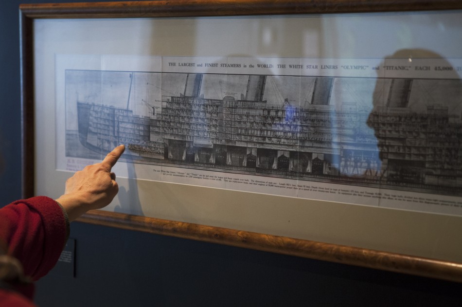 A patron points at a diagram showing the interior of the Titanic that hangs on the wall of an exhibit in the South Street Seaport Museum