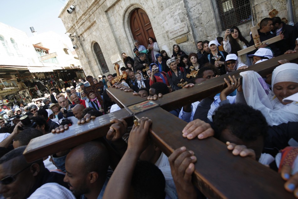 A Christian worshipper holds a cross as she takes part in the Eastern and Orthodox Churchs Good Friday procession in Jerusalem