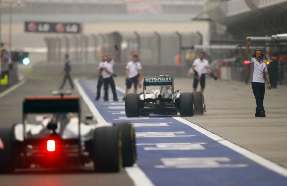 McLaren Formula One driver Hamilton and Mercedes039 Schumacher drive in the pit lane after the qualifying session of the Chinese F1 Grand Prix at Shanghai circuit
