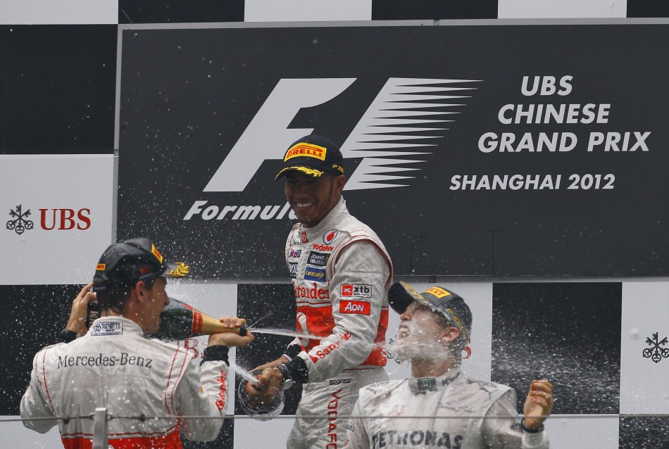 McLaren Formula One driver Button, team mate Hamilton and Mercedes039 Rosberg spray champagne at each other during the podium ceremony following the Chinese F1 Grand Prix at Shanghai circuit