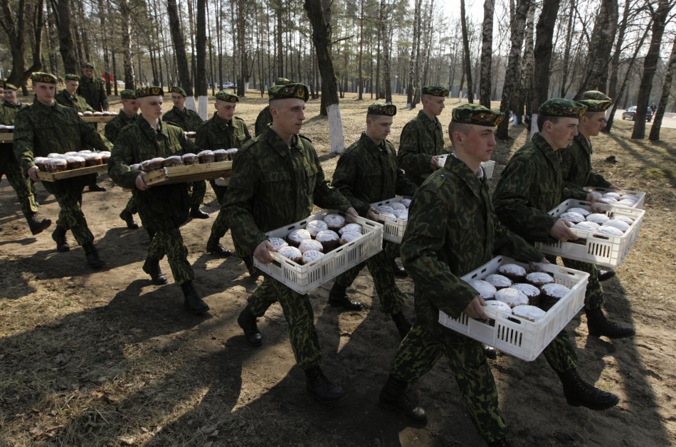 Belarussian Interior Ministry soldiers carry cakes after Orthodox Easter service at a military base near village of Okolitsa