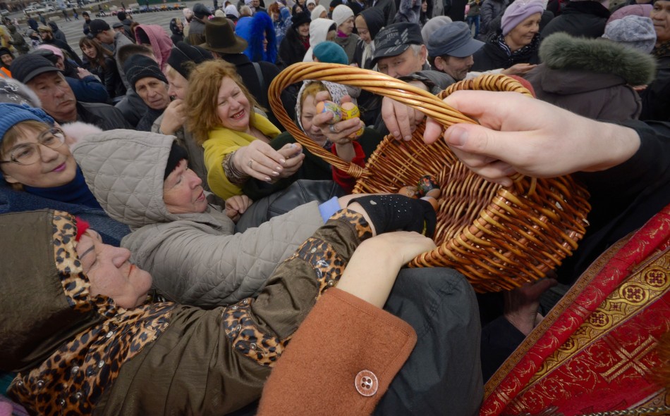 Worshippers take Easter eggs from a basket as they are distributed by an Orthodox priest after a religious service in Russias far Eastern port of Vladivostok