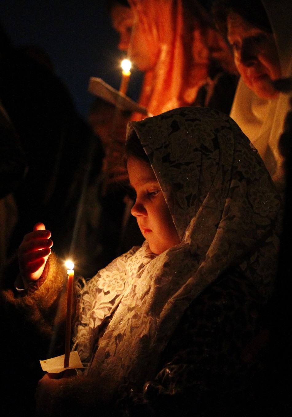 Russian Orthodox Old Believers hold candles during an Easter service at a church in Moscow