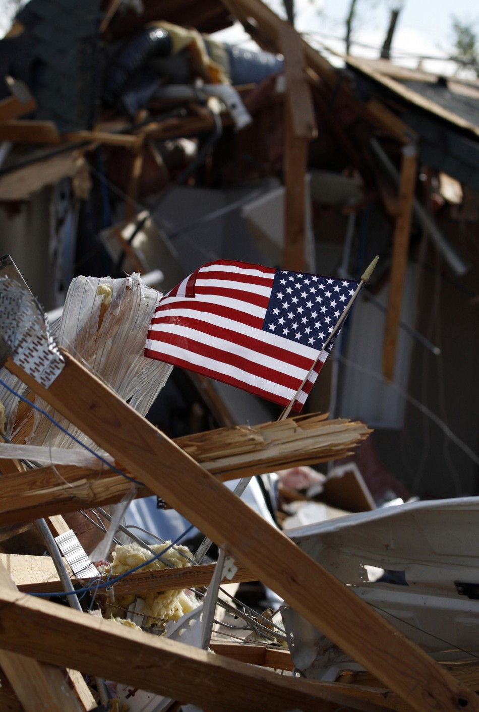 An American flag flies in the rubble of a home that was destroyed by a tornado in Woodward