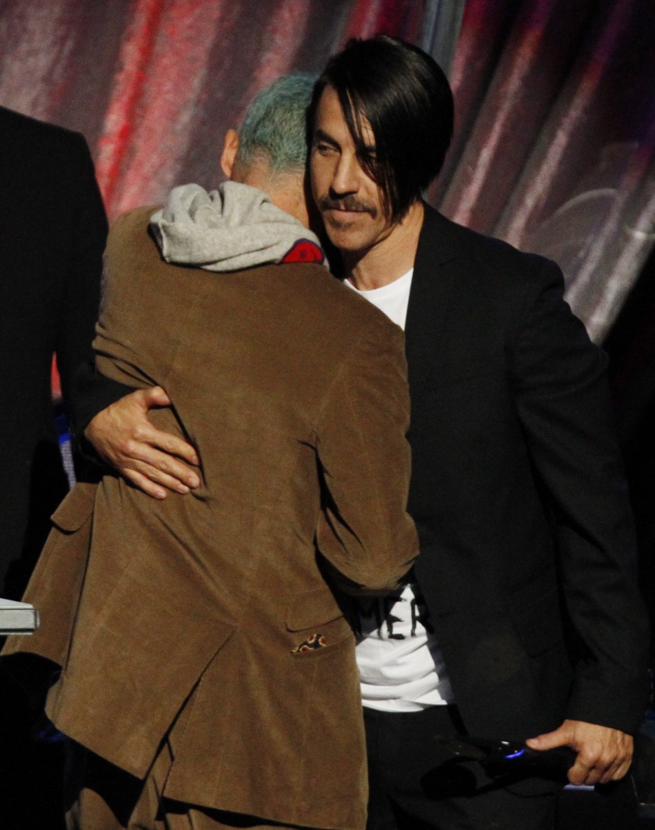 Lead singer Anthony Kiedis hugs band member Flea as the Red Hot Chili Peppers are inducted into the Rock n Roll Hall of Fame in Cleveland, Ohio