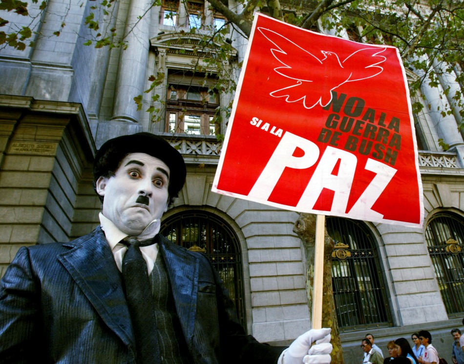 A mime impersonating actor Charlie Chaplin holds a peace sign during a protest in downtown Santiago