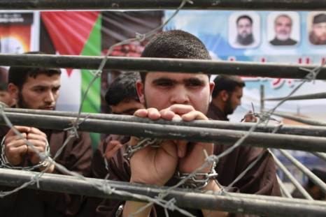 Hamas supporter portrays plight of Palestinian prisoners behind bars at rally in Jabalya, along northern Gaza Strip