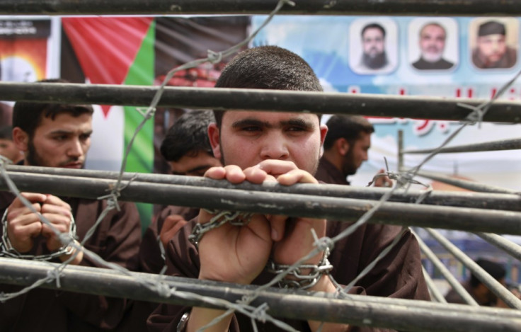 Hamas supporter portrays plight of Palestinian prisoners behind bars at rally in Jabalya, along northern Gaza Strip