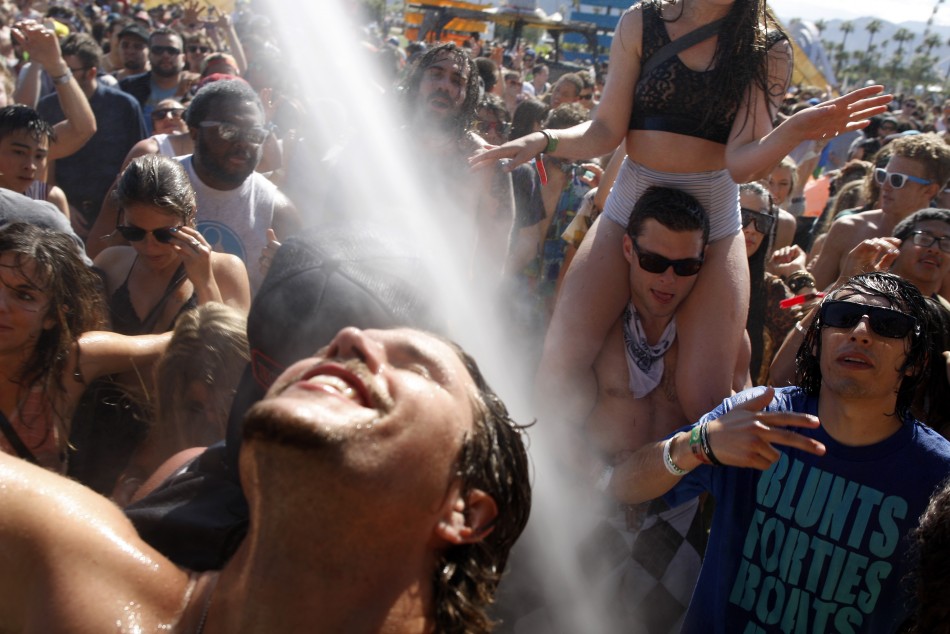 People dance under water sprayed from hoses at the Do Lab at the 2012 Coachella Valley Music and Arts Festival in Indio, California