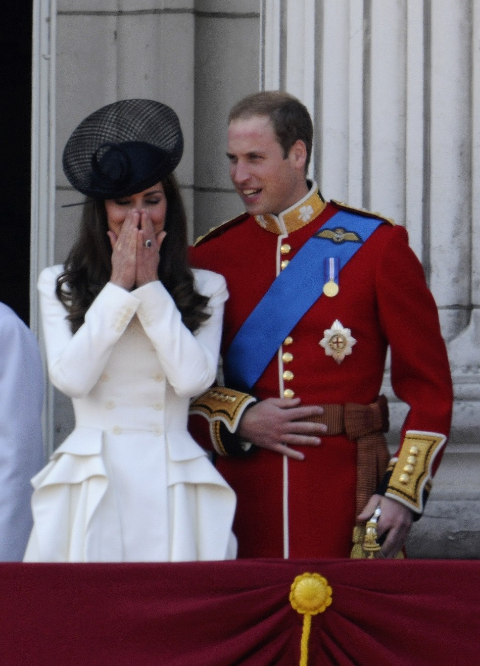 Britain039s Prince William and his wife Catherine, Duchess of Cambridge, share a light moment on the balcony of Buckingham Palace after attending the Trooping the Colour ceremony in central London