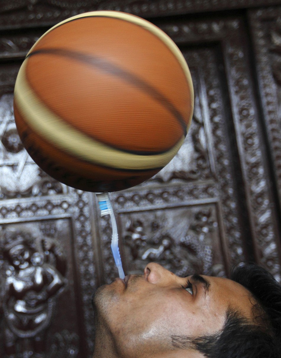 Thaneshwar Guragai spins a basketball on a toothbrush while holding the toothbrush in his mouth for exactly 22.41 seconds to break the last Guinness record of 13.5 seconds set by Thomas Connors of U.K, in Kathmandu