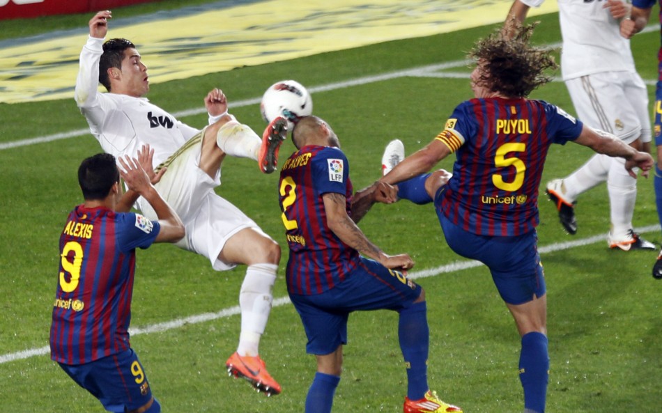 Real Madrid039s Ronaldo kicks the ball surrounded by Barcelona039s Alexis, Alves and Puyol during their Spanish first division quotEl Clasicoquot soccer match in Barcelona