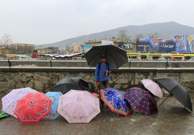 A boy sells umbrellas along a river in Kabul April 19, 2012.