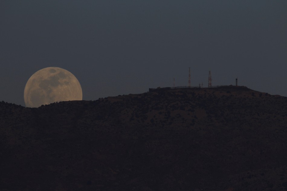 The full moon rises from the top of the Haramoun mountain