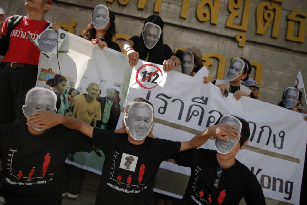 Protesters against Thailand’s lese-majeste laws wear masks and hold pictures of Amphon Tangnoppaku, who has died during whole serving a 20-year sentence for defaming the Queen (Reuters) Protesters against Thailand’s lese-majeste laws wear masks and hold pictures of Amphon Tangnoppaku, who has died during whole serving a 20-year sentence for defaming the Queen (Reuters)