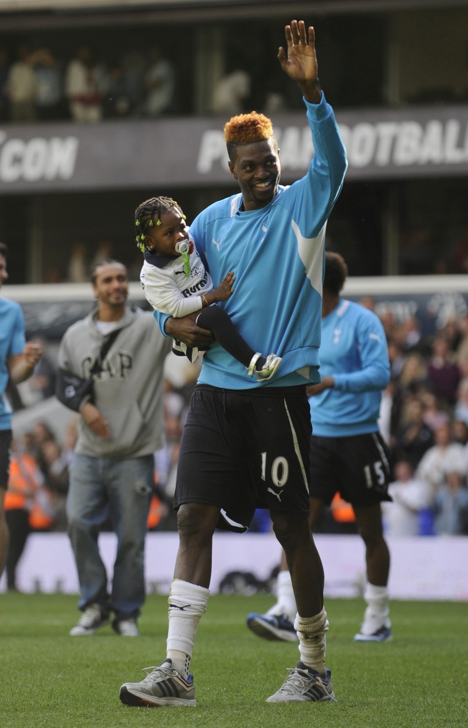 Adebayor, who was on a season-long loan at Tottenham from Manchester City, holds his daughter as he waves to fans after the English Premier League match against Fulham at White Hart Lane