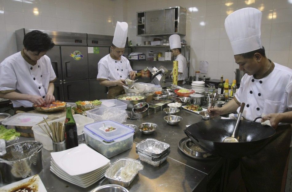 Chefs prepare food inside the kitchen of an A380 theme restaurant, in Chongqing municipality