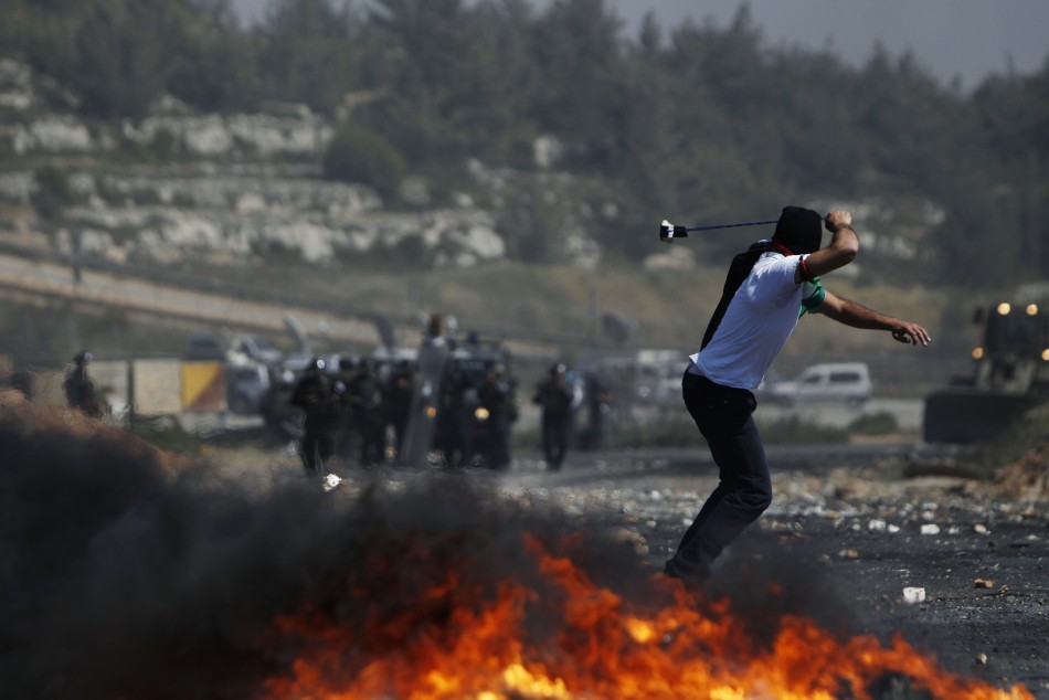 A Palestinian protester uses a sling to hurl stones at Israeli troops during clashes on Nakba day