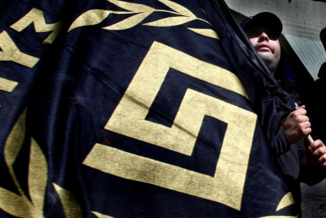 Member of Greece's extreme-right Golden Dawn party holds flag bearing party logo during election campaign rally in Athens