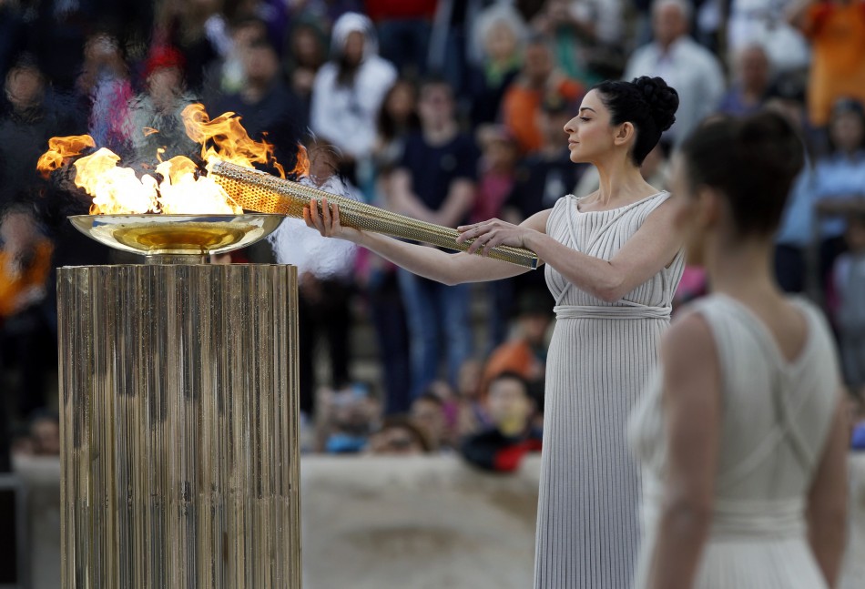 Ino Menegaki, a Greek actress, in the role of an ancient high-priestess, lights a torch from a cauldron with the Olympic Flame