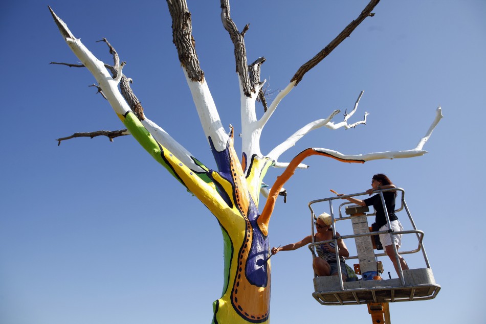 Artists Emily Frankoski and Dolores Bilke paint a tornado damaged tree in Joplin