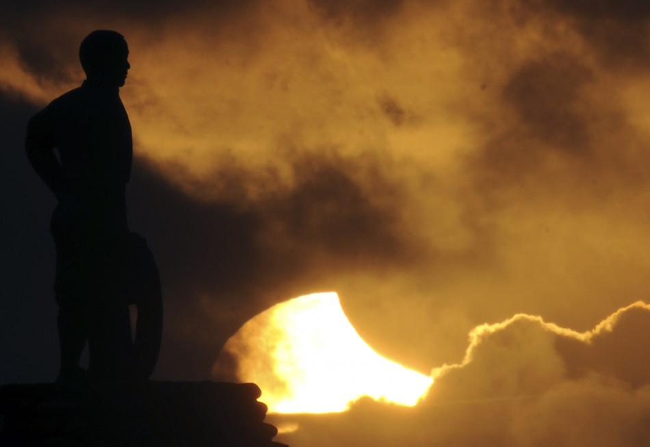 A partial eclipse is pictured behind a statue in Taiwan039s notherneast coast in New Taipei city