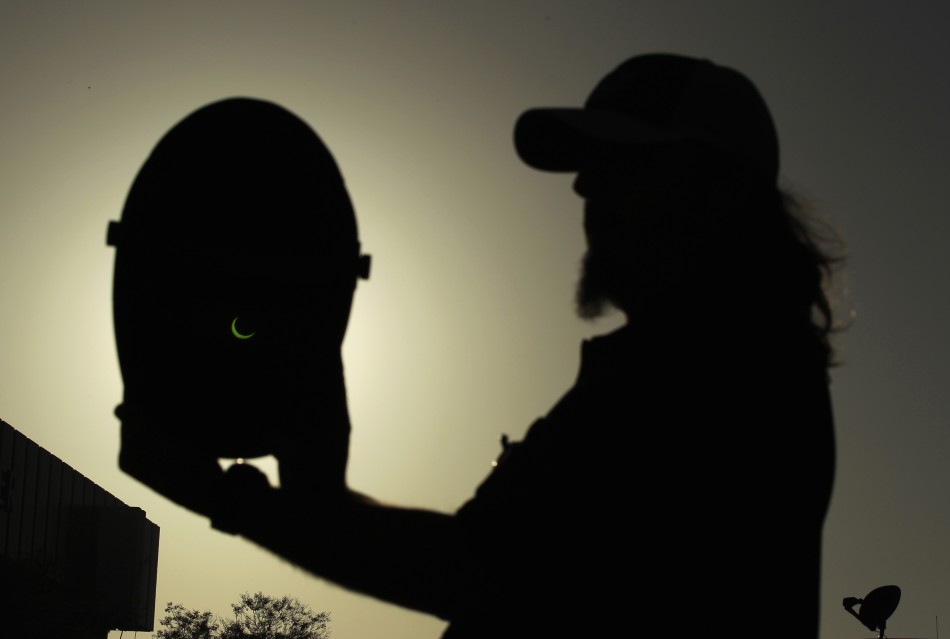 Dennis Vitt, 38, looks at an annular eclipse through a welding mask in Los Angeles