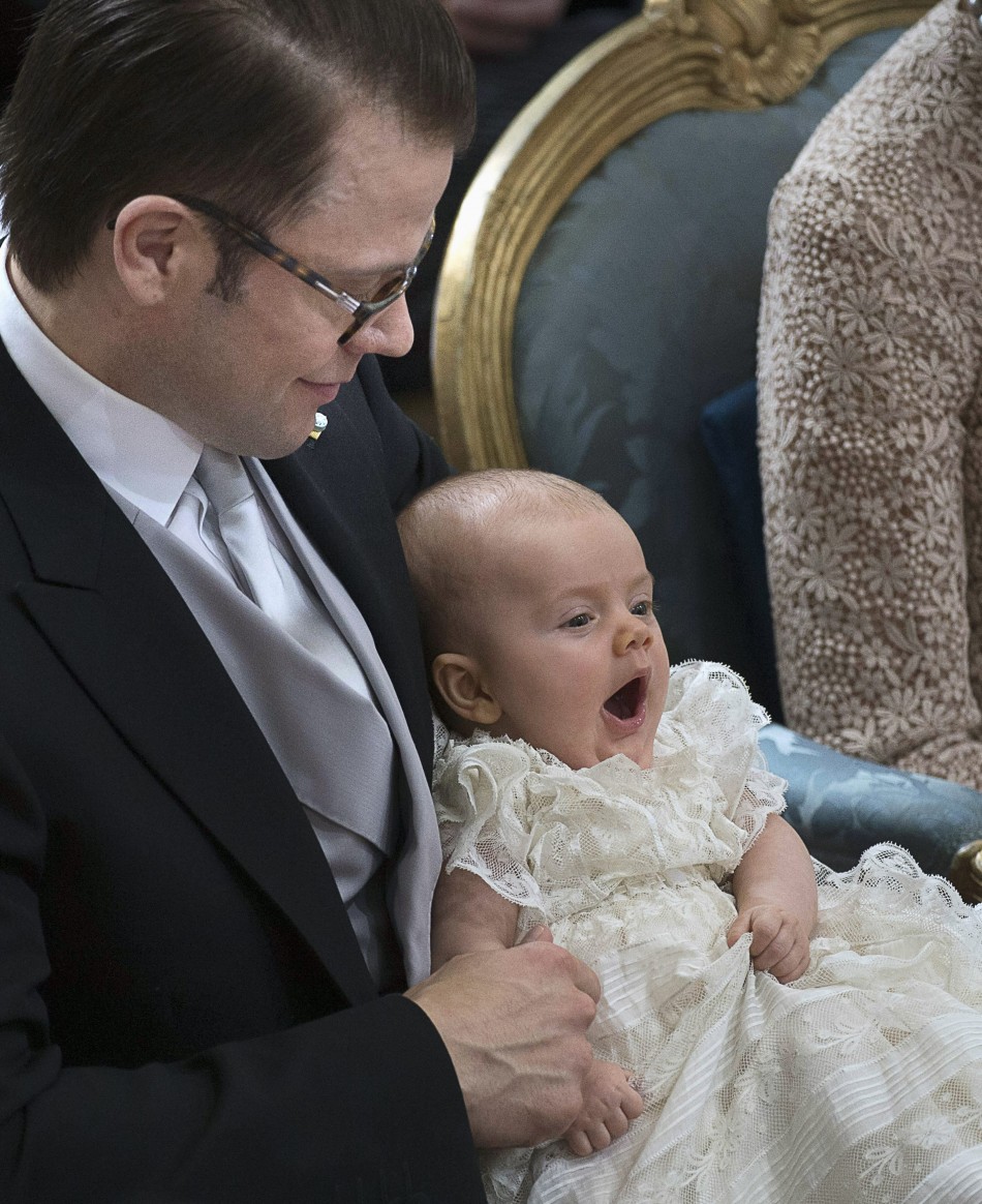 Swedens Prince Daniel holds Princess Estelle who yawns during her christening ceremony in the Royal Chapel in Stockholm