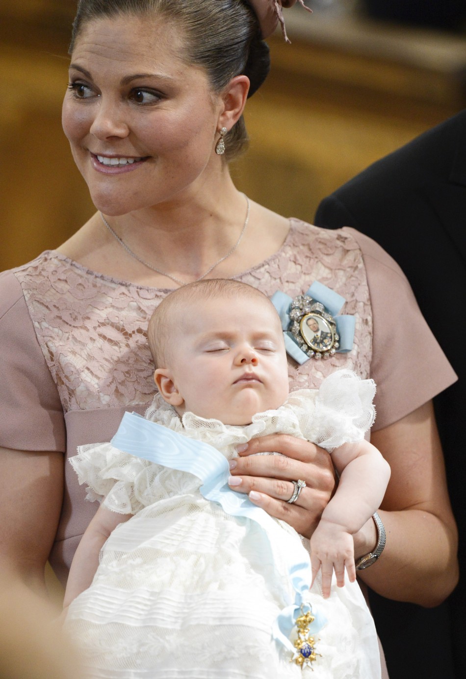 Swedens Crown Princess Victoria holds Princess Estelle as she stands with Prince Daniel after the christening ceremony, held at the Royal Chapel in Stockholm