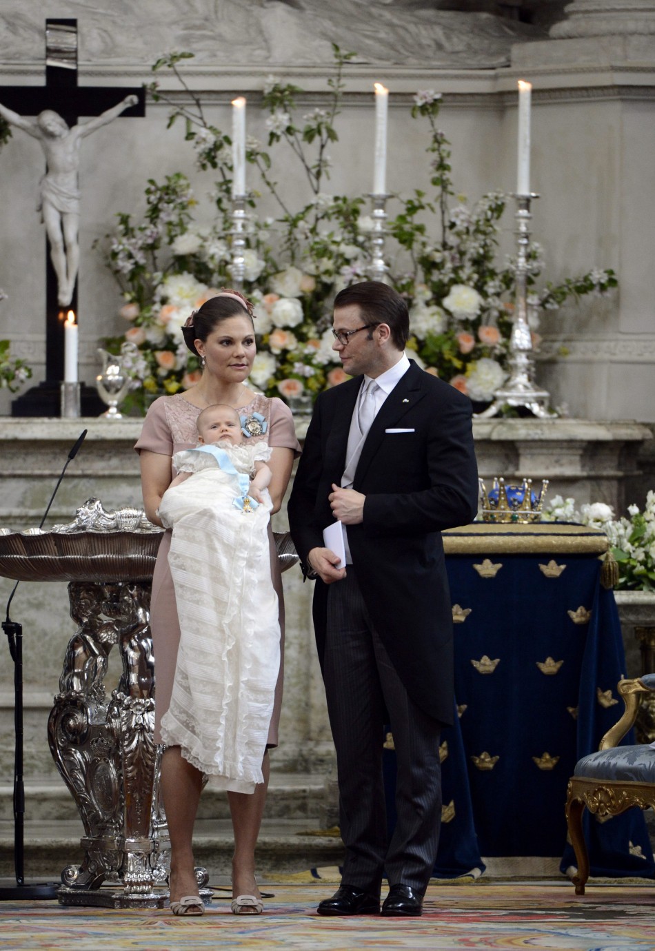 Swedens Crown Princess Victoria holds Princess Estelle as she stands with Prince Daniel after the christening ceremony, held at the Royal Chapel in Stockholm